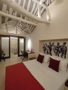 ein Schlafzimmer mit einem großen weißen Bett mit einem Gemälde an der Wand in der Unterkunft Mangala Heritage by LuxUnlock Private Villas in Tirukkannapuram