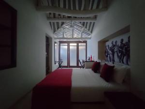 ein Schlafzimmer mit einem großen Bett mit einer roten und weißen Decke in der Unterkunft Mangala Heritage by LuxUnlock Private Villas in Tirukkannapuram