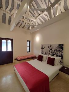 ein Schlafzimmer mit einem großen Bett mit einer roten Decke in der Unterkunft Mangala Heritage by LuxUnlock Private Villas in Tirukkannapuram