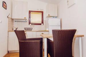 斯塔利格拉德－帕克萊尼采的住宿－Modern Apartment in Starigrad with Garden，厨房配有两把椅子、一张桌子和一台冰箱