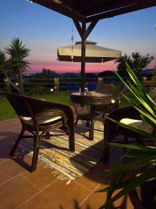 a patio with a table and chairs and an umbrella at Nikitihouse Apartments 1 in Nikiti
