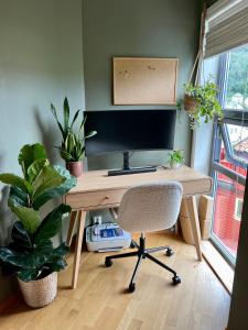 a wooden desk with a computer monitor and a chair at Top floor apartment with mountain view, terrace 22sqm, free parking in Bergen