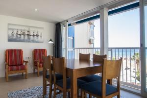 Apartamentos Torre Yago في بنيدورم: غرفة طعام مع طاولة وكراسي وشرفة