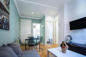 uma sala de estar com um sofá e uma mesa em Apartamentos Dali Madrid em Madri