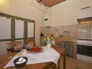 Lovely farmhouse in Tuscany with panoramic view في كاستل براردينغا: مطبخ مع طاولة مع أكواب من النبيذ
