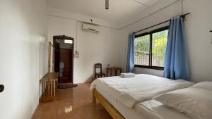 sokxay guerthouse في فانغ فينغ: غرفة نوم بسرير ونافذة كبيرة