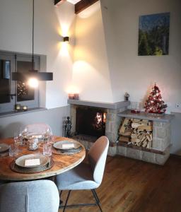 een woonkamer met een tafel en een open haard bij Apartamento PinosPenthouse pie de pistas La Molina in La Molina