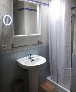 een badkamer met een wastafel, een spiegel en een douche bij Apartamento PinosPenthouse pie de pistas La Molina in La Molina