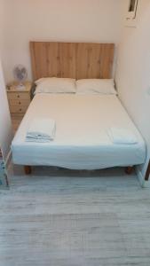 Bett in einem Zimmer mit einem Kopfteil aus Holz in der Unterkunft Gomecin's studio - C/ d'Osca 4 in Salou