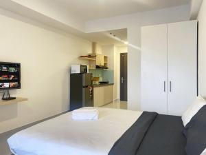 a bedroom with a large bed and a black refrigerator at SOHO 23 Floor Stunning City View Apartment Near Bui Vien Ben Thanh in Ho Chi Minh City