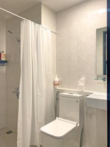 a white bathroom with a toilet and a sink at SOHO 23 Floor Stunning City View Apartment Near Bui Vien Ben Thanh in Ho Chi Minh City