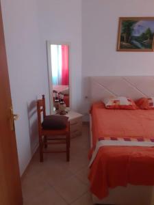 1 dormitorio con cama, silla y espejo en Beach apartment durres, en Durrës