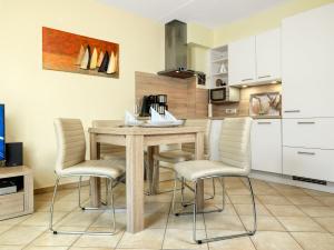 cocina con mesa de madera y sillas en Appartement Mien to hus, en Kirchdorf