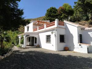 a large white house with a driveway at Casa Rural Las Adelfas in Cómpeta