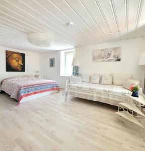 a white bedroom with a bed and a couch at Cap Bonheur 