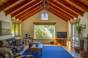 a living room with leather furniture and a large window at The River House Wanaka in Wanaka