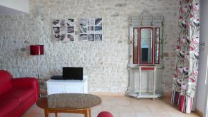 un soggiorno con divano rosso e tavolo di Le Gîte ROUGE a Saujon
