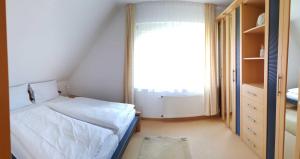 a small bedroom with a bed and a window at Urlaubslust Ferienhaus 16 in Trassenheide