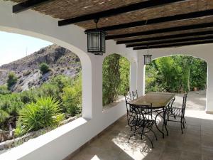 a patio with a table and chairs and a mountain at Casa Rural Las Adelfas in Cómpeta