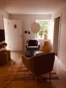 uma sala de estar com um sofá e uma cadeira em Villa med private værelser og delt køkken/badrum, centralt Viby sj em Viby