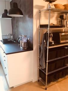 een keuken met een plank met potten en pannen bij Villa med private værelser og delt køkken/badrum, centralt Viby sj in Viby