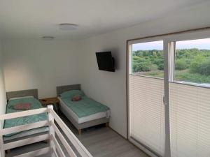a room with two beds and a balcony with a window at Zielony Daszek in Sianozety