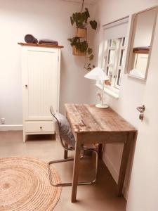 un escritorio de madera con una silla y una lámpara. en Villa med private værelser og delt køkken/badrum, centralt Viby sj en Viby