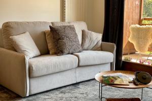 a living room with a couch and a table at Les Lucioles - Charming flat in the mountains in Saint-Jean-de-Sixt