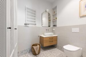 a white bathroom with a sink and a toilet at NORDBYHUS Apartamenty Seredyńskiego in Gdańsk