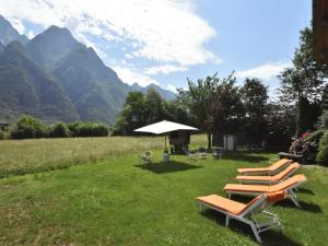 een groep ligstoelen en een paraplu in een veld bij Agriturismo La Ca' Vegia in San Cassiano