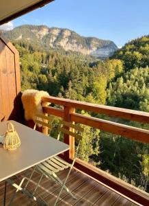 einen Balkon mit einem Tisch und Bergblick in der Unterkunft Les Lucioles - Charming flat in the mountains in Saint-Jean-de-Sixt