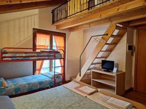 a room with two bunk beds and a tv at Agriturismo La Ca' Vegia in San Cassiano