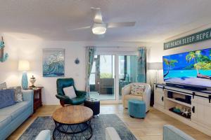 a living room with a couch and a flat screen tv at 380-D - Madeira Beach Yacht Club in St. Pete Beach