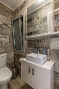 a bathroom with a white sink and a toilet at Serenity house near Heraklion in Stavrákia