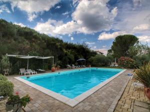 a swimming pool with blue water in a yard at Country House with swimming pool and garden with Mediterranean plants in Bettona