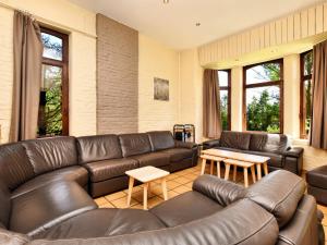sala de estar con sofá de cuero y mesas en Cozy Cottage in Durbuy with Garden, en Barvaux