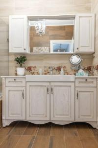 a white kitchen with a sink and a mirror at Serenity house near Heraklion in Stavrákia