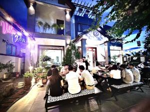 eine Gruppe von Personen, die in einem Restaurant an Tischen sitzen in der Unterkunft Chelsea Villa Moc Chau Venuestay in Mộc Châu