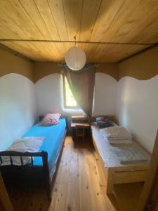 twee bedden in een kamer met een houten plafond bij Gîte atypique in Borrèze