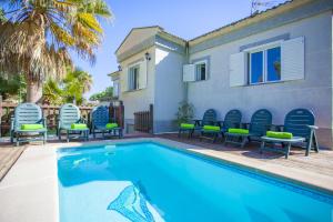 a swimming pool with chairs and a house at Villa Sa Marina -Figuemar- in Alcudia