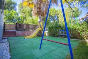 a playground with a slide in a yard at Villa Sa Marina -Figuemar- in Alcudia
