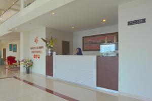 a woman standing at a counter in a hospital lobby at Liberta Hotel Grand Sayang Makassar in Makassar