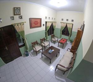 sala de estar con sofá, sillas y mesa en Omah 430 Suryowijayan, en Ngabean