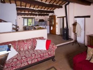 a living room with a red couch and a kitchen at Pretty Holiday Home in Acqualagna with Swimming Pool in Acqualagna