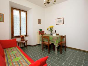 a living room with a table and a red couch at Enticing Apartment in Stresa with Balcony Lake Views in Stresa