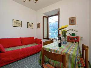 sala de estar con sofá rojo y mesa en Enticing Apartment in Stresa with Balcony Lake Views, en Stresa