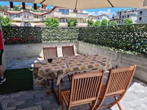 a table with four chairs and an umbrella on a patio at KD Apartment, accogliente, moderno e spazioso. in Castel di Sangro