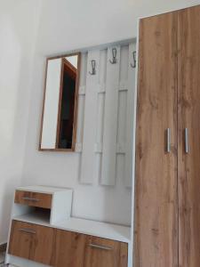 a bathroom with a mirror and a wooden cabinet at Studio με όλες τις ανέσεις in Vétrina