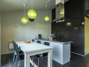 una cocina con una mesa blanca y algunas luces verdes en Boutique Chalet in B llingen Near Lake, en Wirtzfeld