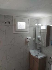 baño con aseo y lavabo y ventana en Studio με όλες τις ανέσεις, en Vétrina